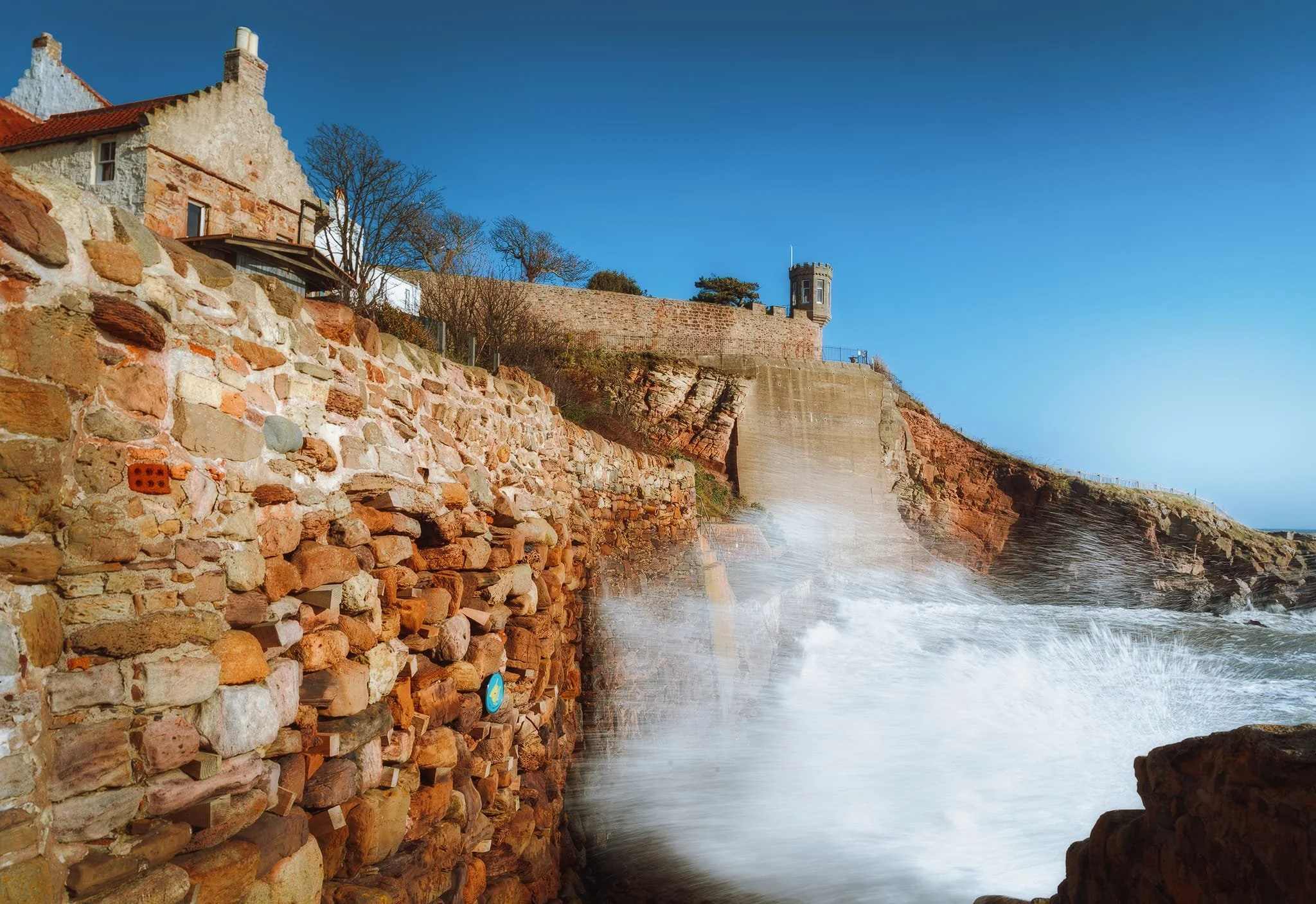Below the old castle fortifications, the full might of the sea and wind were on display, slamming against the harbour walls.