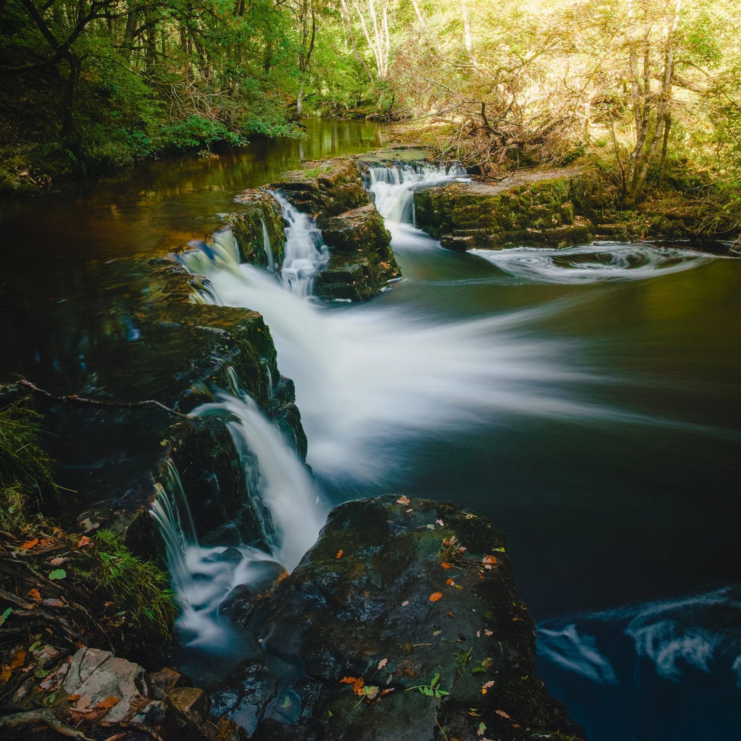 An unnamed waterfall on the Elidir Trail towards Sgwd Gwladys, with a glittering of autumn colours dashed around the scene.