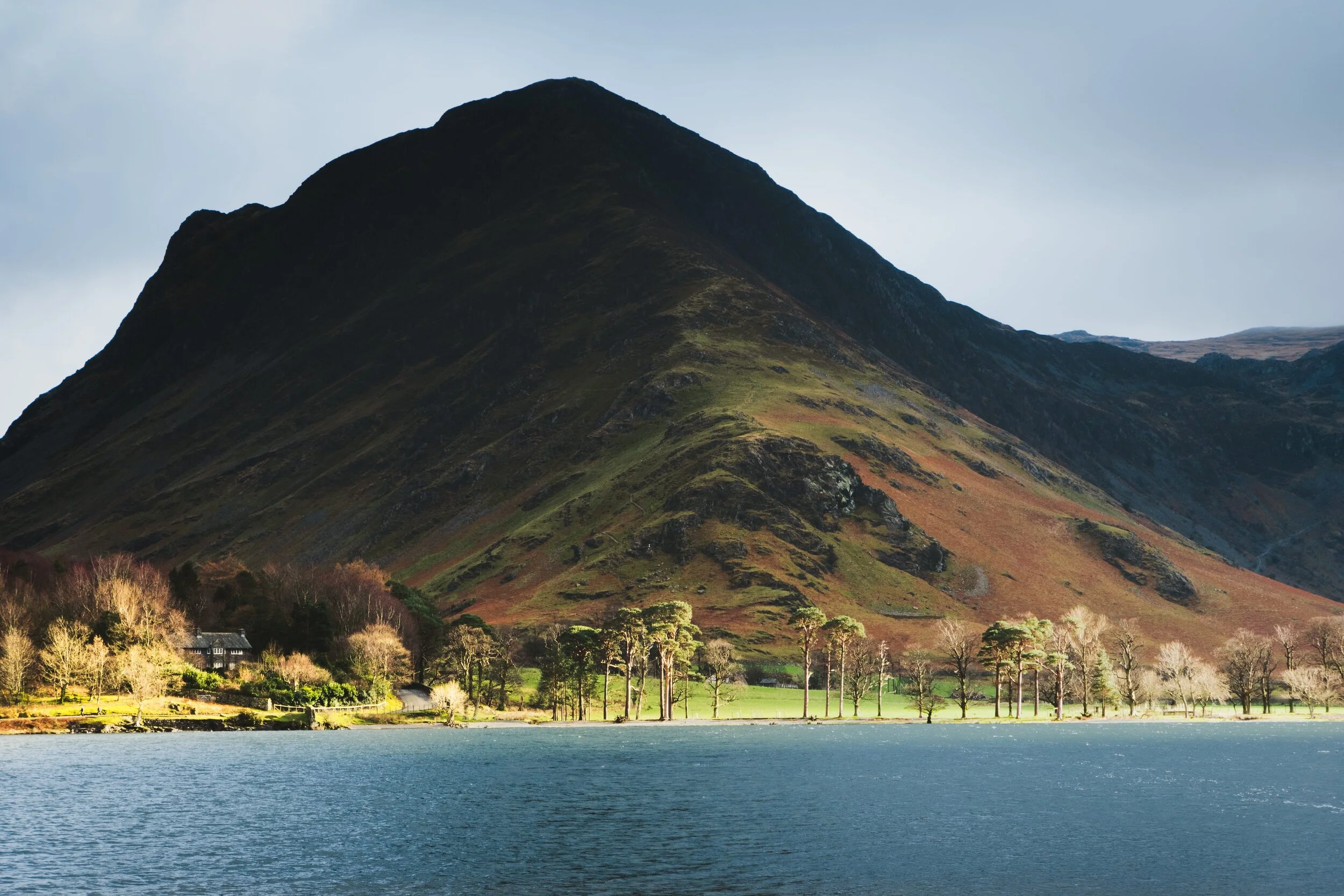 The setting sun illuminates the eastern shore of Buttermere with Fleetwith Pike looming large above.
