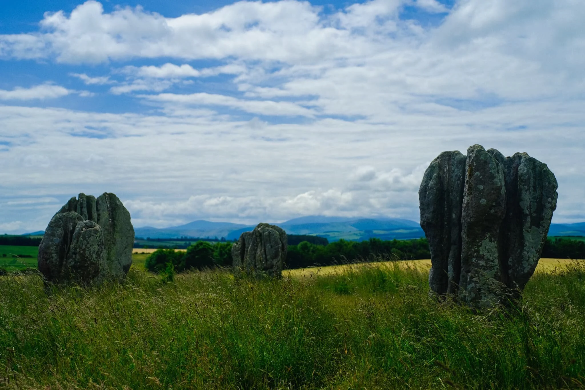 Duddo Five Stones is located on a small hill north of the village of Duddo, and thus they offer panoramic views of the Cheviot Hills to the south and the Lammermuir Hills to the north. In view in this composition are the Cheviot Hills.