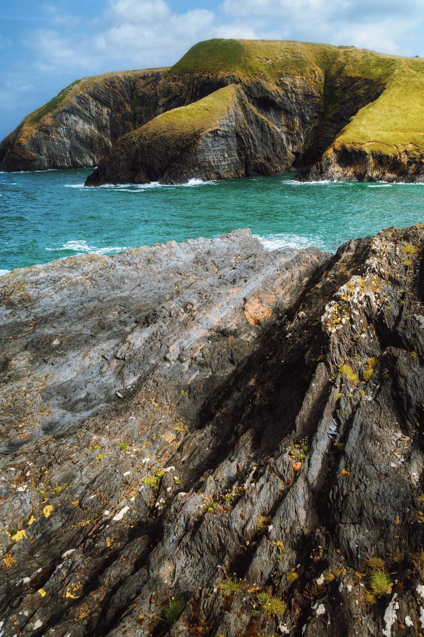 In fact, part way up the western clifftop path a small desire line branches off back down towards the sea. We followed it, finding these amazing folds and grooved formations, which I used as leading lines towards the folded cliffs.
