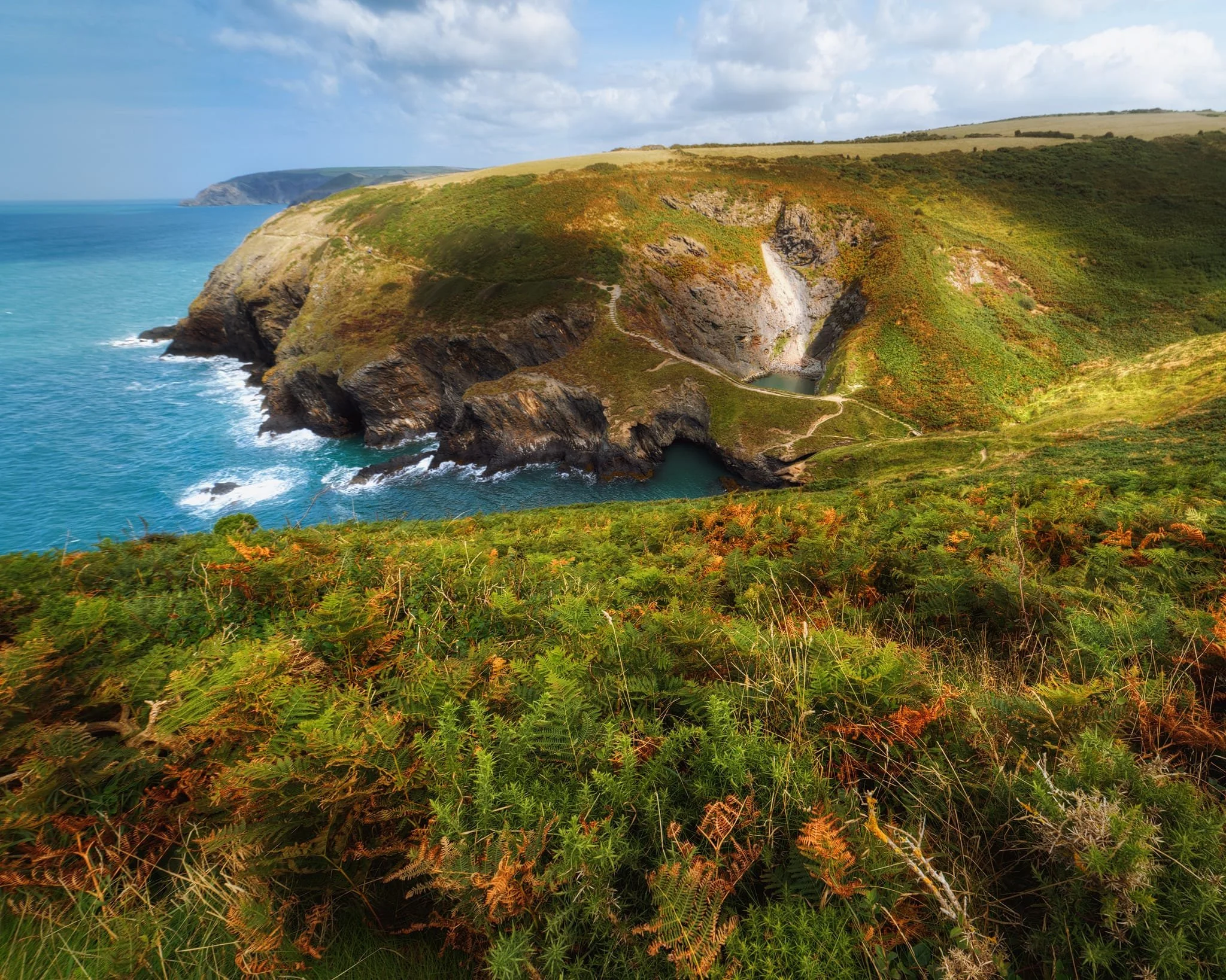 Further southwest from above, it’s clear to see how Pwll y Wrach is a collapsed cave. Who knows how long the land bridge separating the cauldron from the sea will last?
