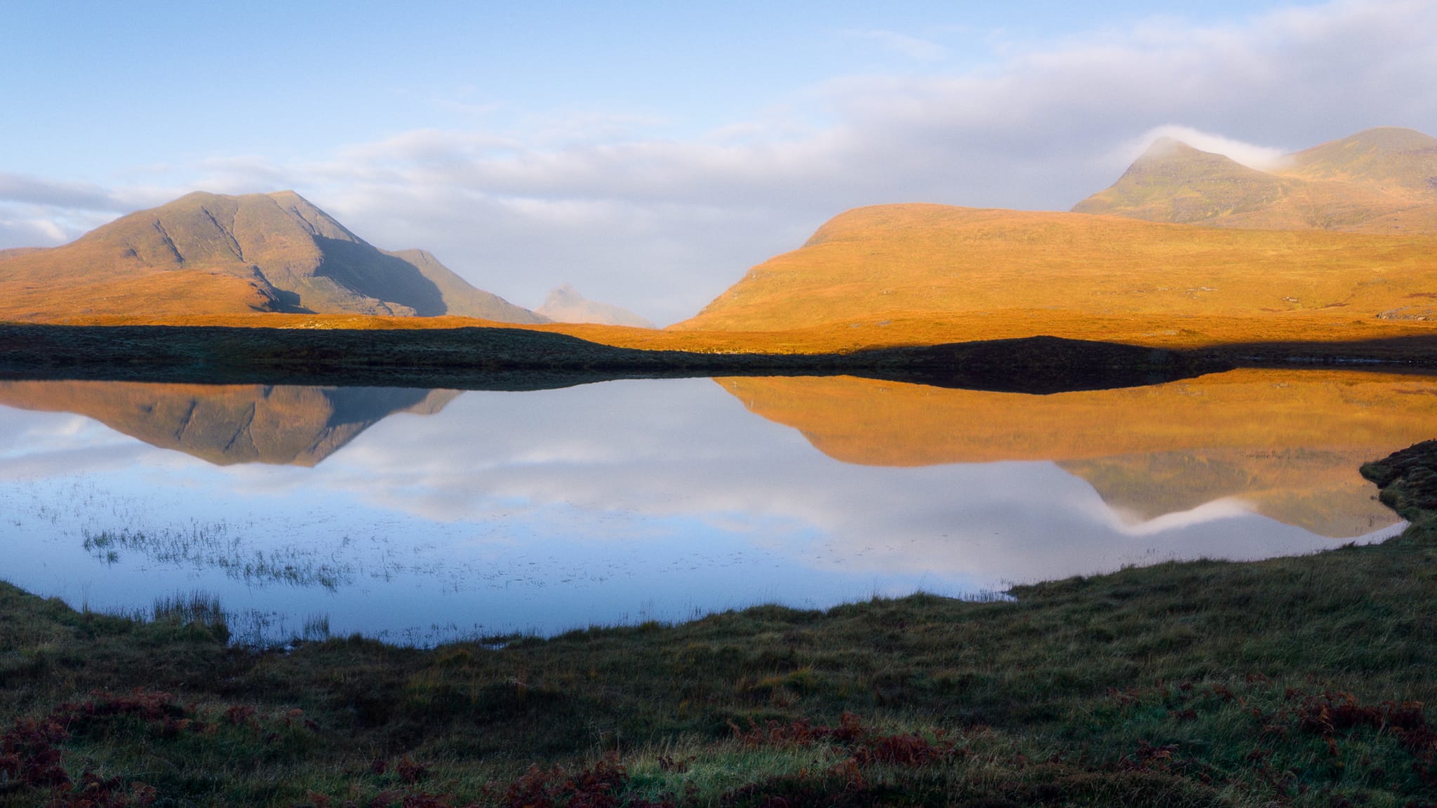 On another day, heading towards Lochinver one early morning, we hurriedly stopped at one of the A835&rsquo;s many parking areas as our eyes caught a glimpse of perfect reflections. Here, across a still Lochan an Ais, the rising sun drenched Stac Pollaidh, Cùl Beag, and Cùl Mòr in beautiful autumnal orange. A scene I&rsquo;ll never forget.