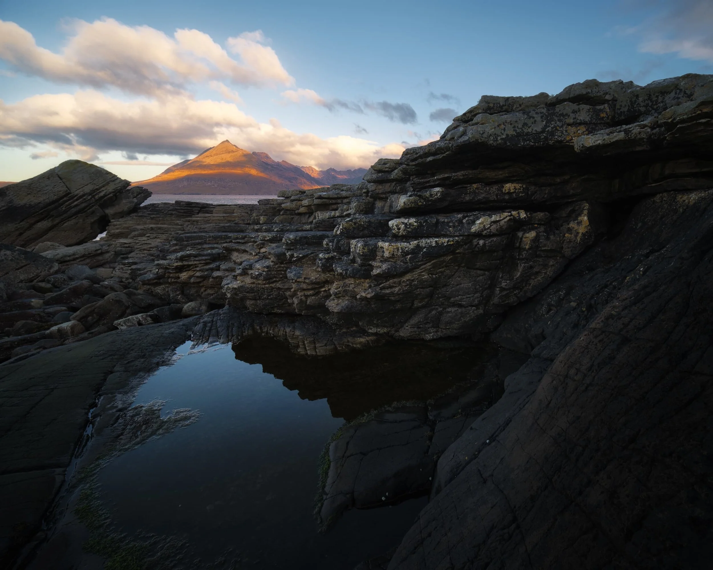 I immediately picked my way towards the northwestern shore, looking for compositions featuring some of Elgol’s weird and wonderful rock formations. I found this stack of rock shelves, perhaps an Uncomformity , which I used as a leading line towards the glowing Black Cuillins (the particular member of the Black Cuillins pictured is Gars-bheinn , pronounced GAR-vein, meaning “rough mountain”).