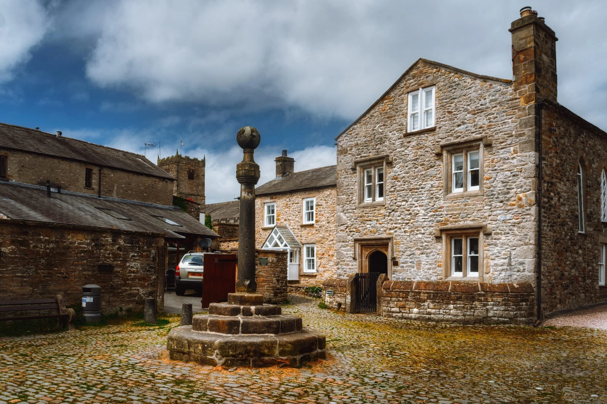 This little area down Red Dragon Yard and Mill Brow is known as Swine Market because, historically, that’s what this area was. The pillar structure is the Old Market Cross, formerly located at the junction of Main Street, Market Street, and Mill Brow. It was relocated to Swine Market in 1822. The steps and crowning ball were a later addition.