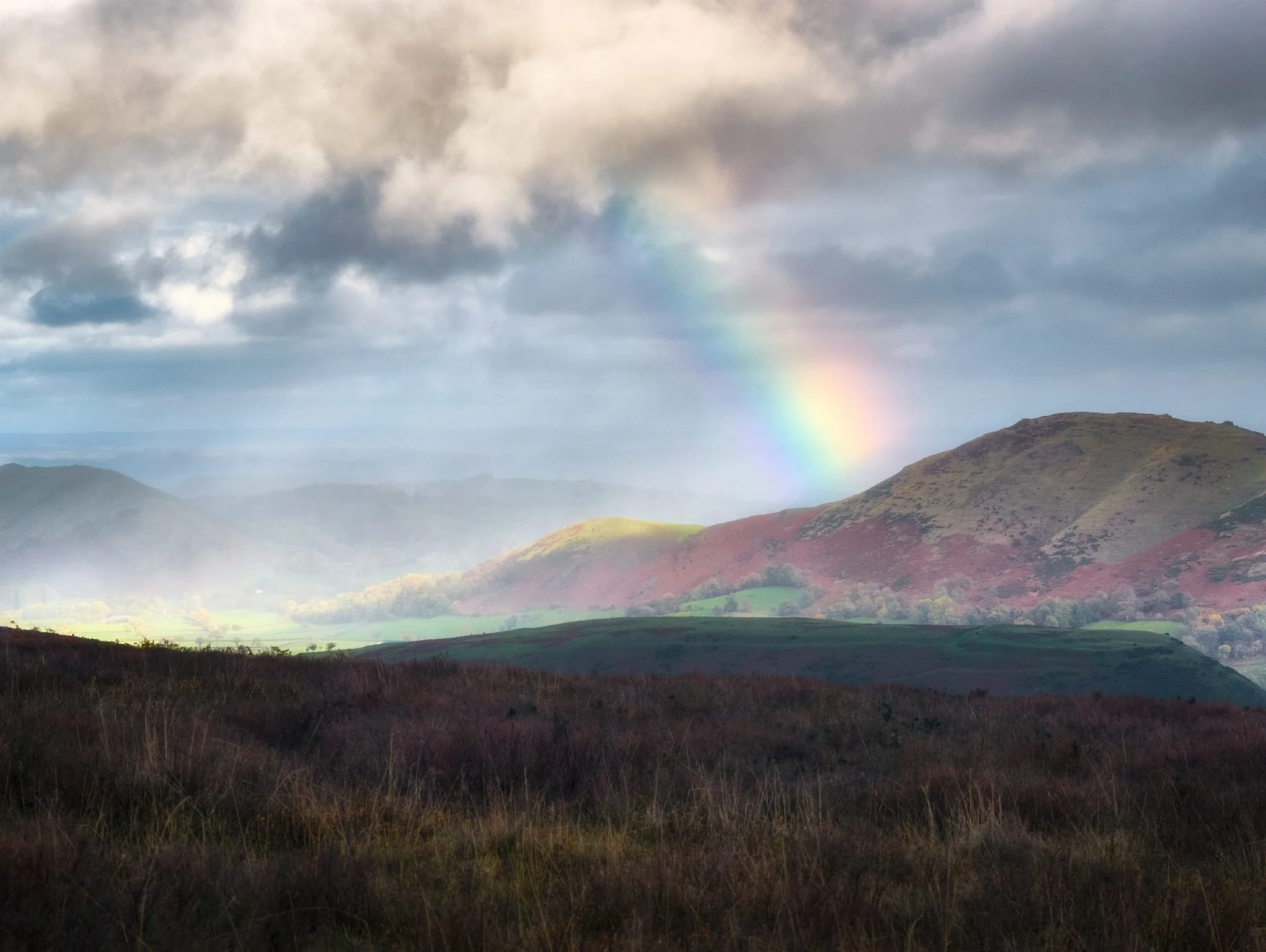Soon afterwards we “enjoyed” a series of squalls drenching us. However, that did mean we got this superb light show of a rainbow hitting Caer Caradoc and a focused spotlight illuminating the northern Stretton Gap.