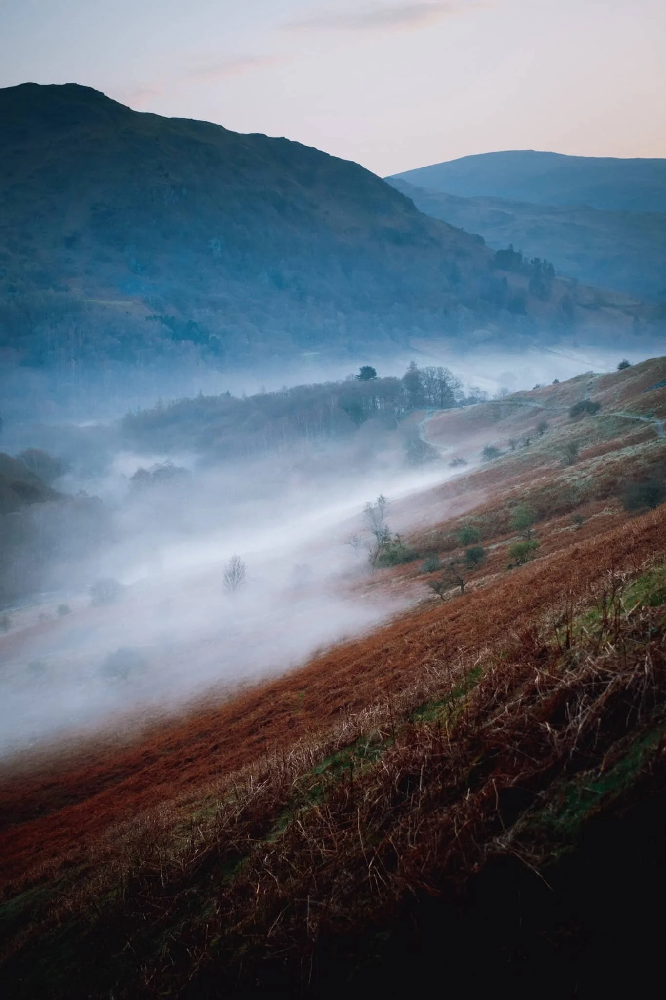 As we began ascending the main footpath up Loughrigg Fell the views quickly opened up. From Loughrigg Terrace the temperature inversion was more visible, and I couldn’t resist this composition of the mist clinging to the valley, with Nab Scar (455 m/1,493 ft) looming above.