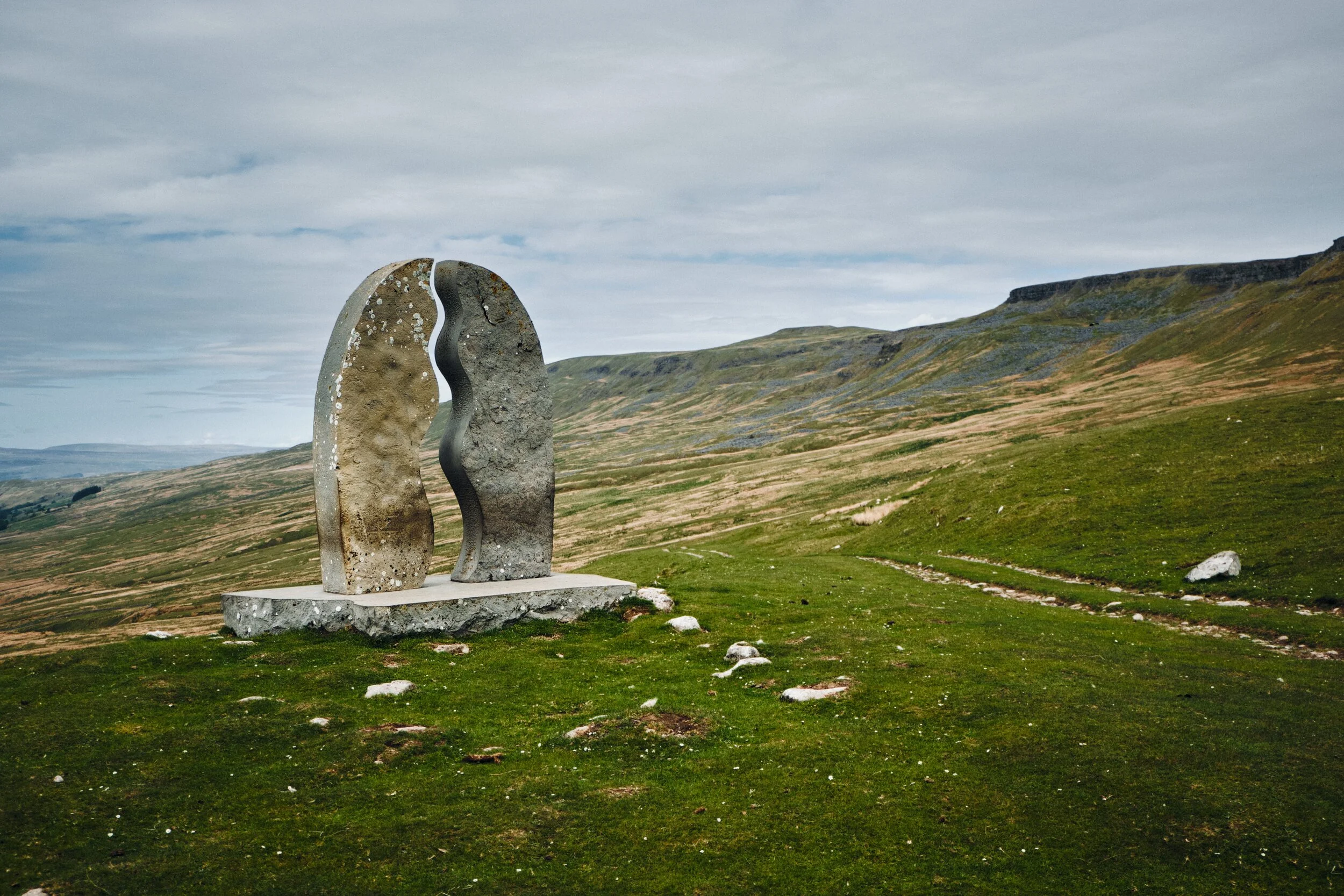 This sculpture, found on the Pennine Bridleway, is called “Watercut” by Mary Bourne . The watery gap that divides the sculpture utilises the changing sky to echo the ever-changing flow of water. To the right is the flat-topped Mallerstang Edge.