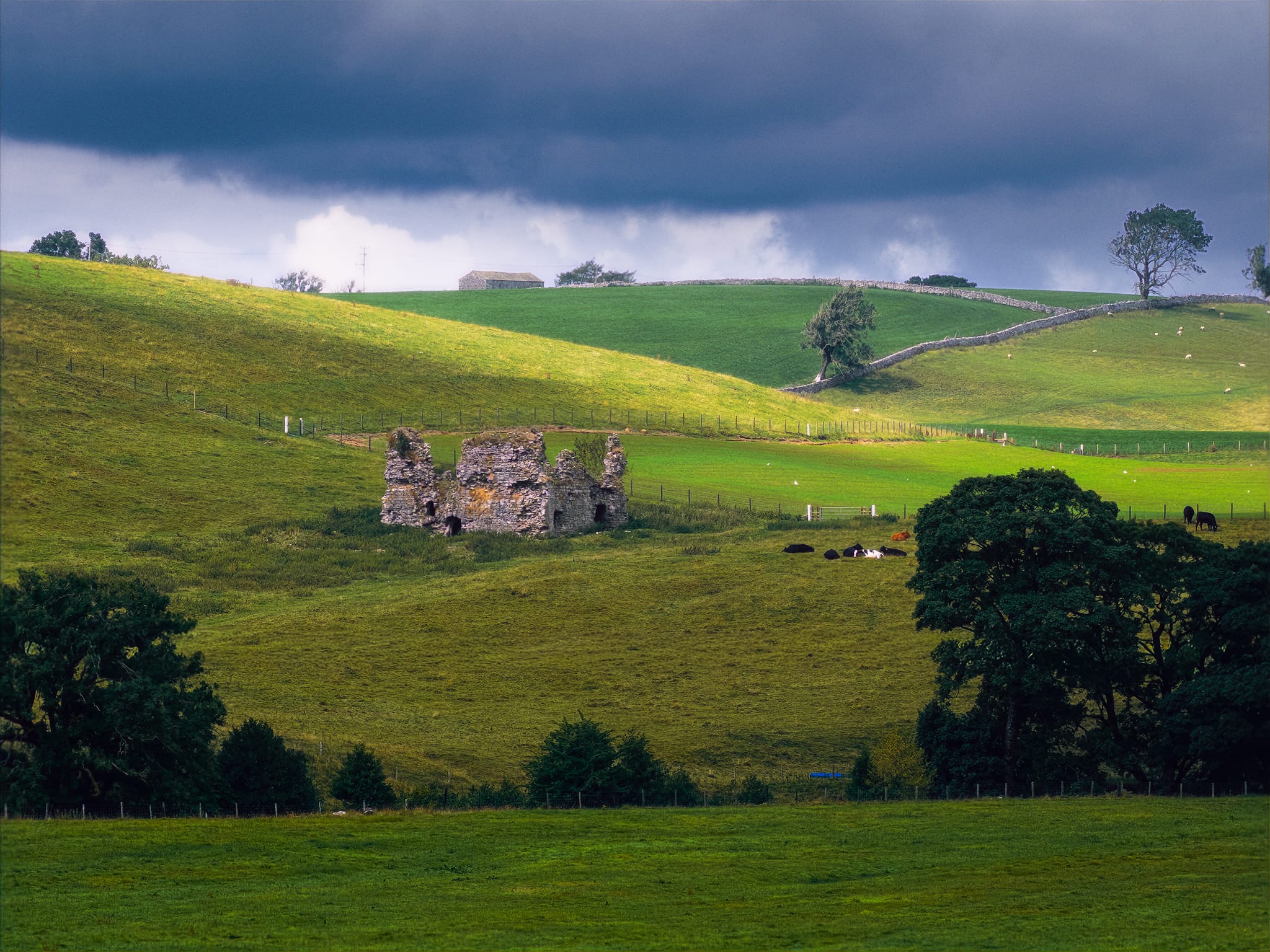 Our destination: Lammerside Castle, with a sliver of light breaking through the thick clouds and scanning across the rolling curves of the landscape.