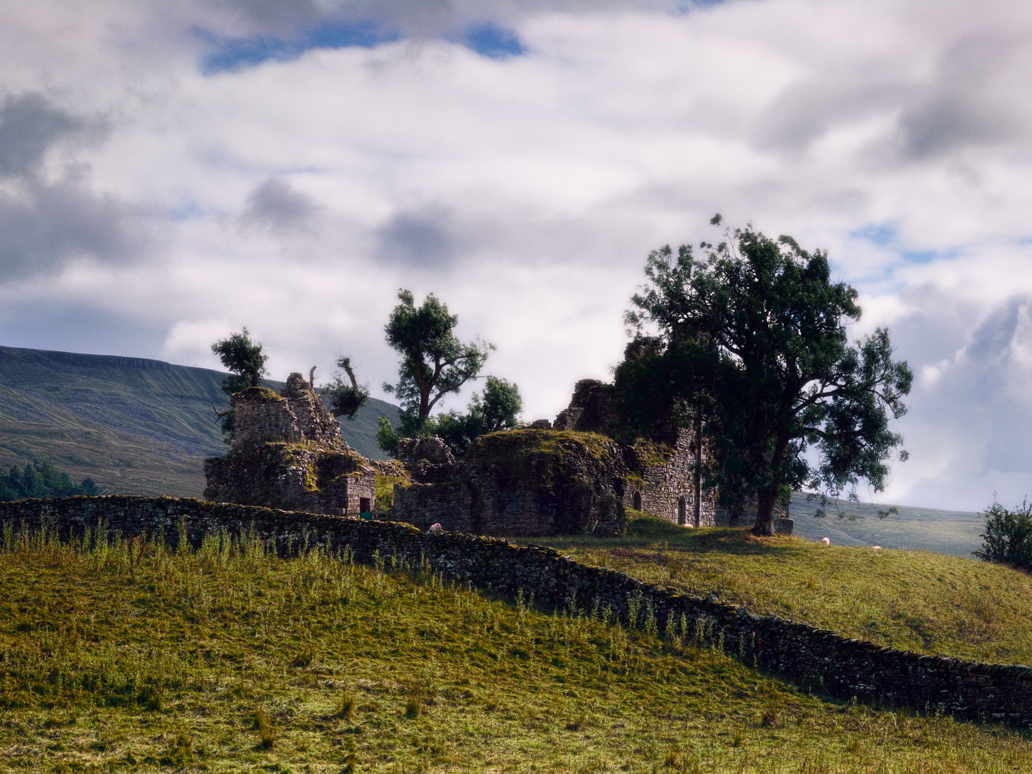 The ruins of Pendragon Castle, bathed in light, nature slowly reclaiming it.