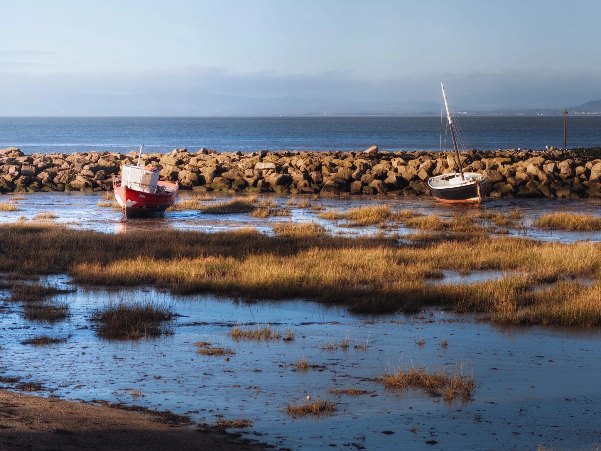 The tide at Morecambe Bay moves fast . Moored boats were already emerging from their watery parking area.