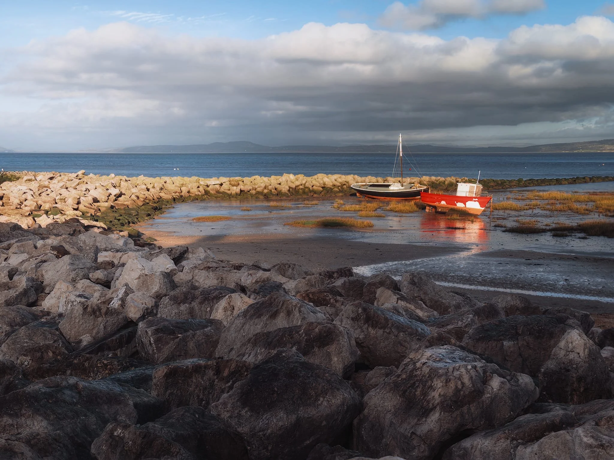 As the tide rushed out the clouds were moving in, allowing for golden localised light to illuminate only this breakwater and the boats moored within it.