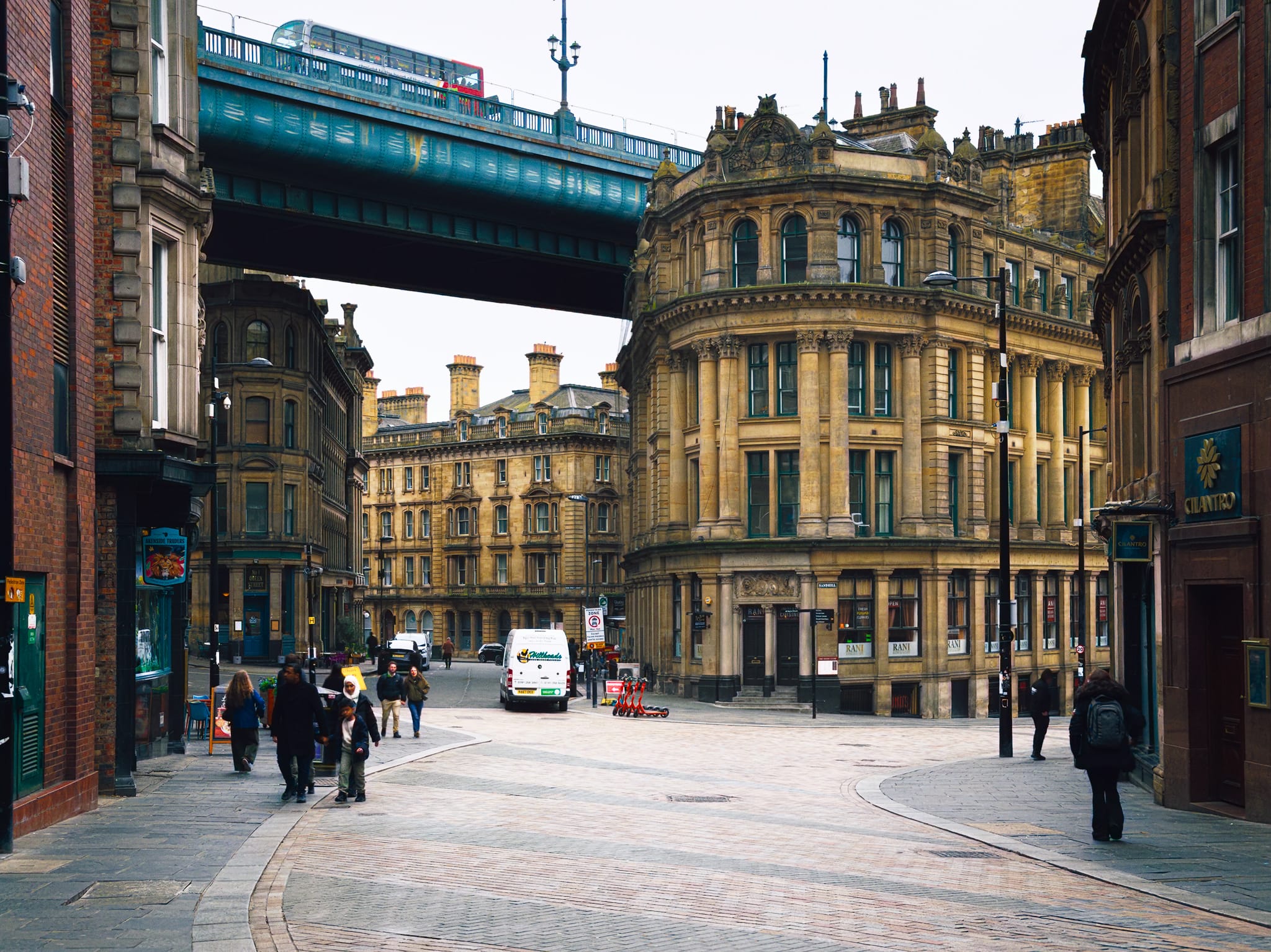 This image attracts and intrigues me. It puts me in mind of Dieselpunk or Steampunk vibes, y’know? This is the view heading down Quayside, showing off the Phoenix House — a Grade II listed building constructed in 1869 for the Royal Insurance Company — and the Tyne Bridge that fits snugly overhead.