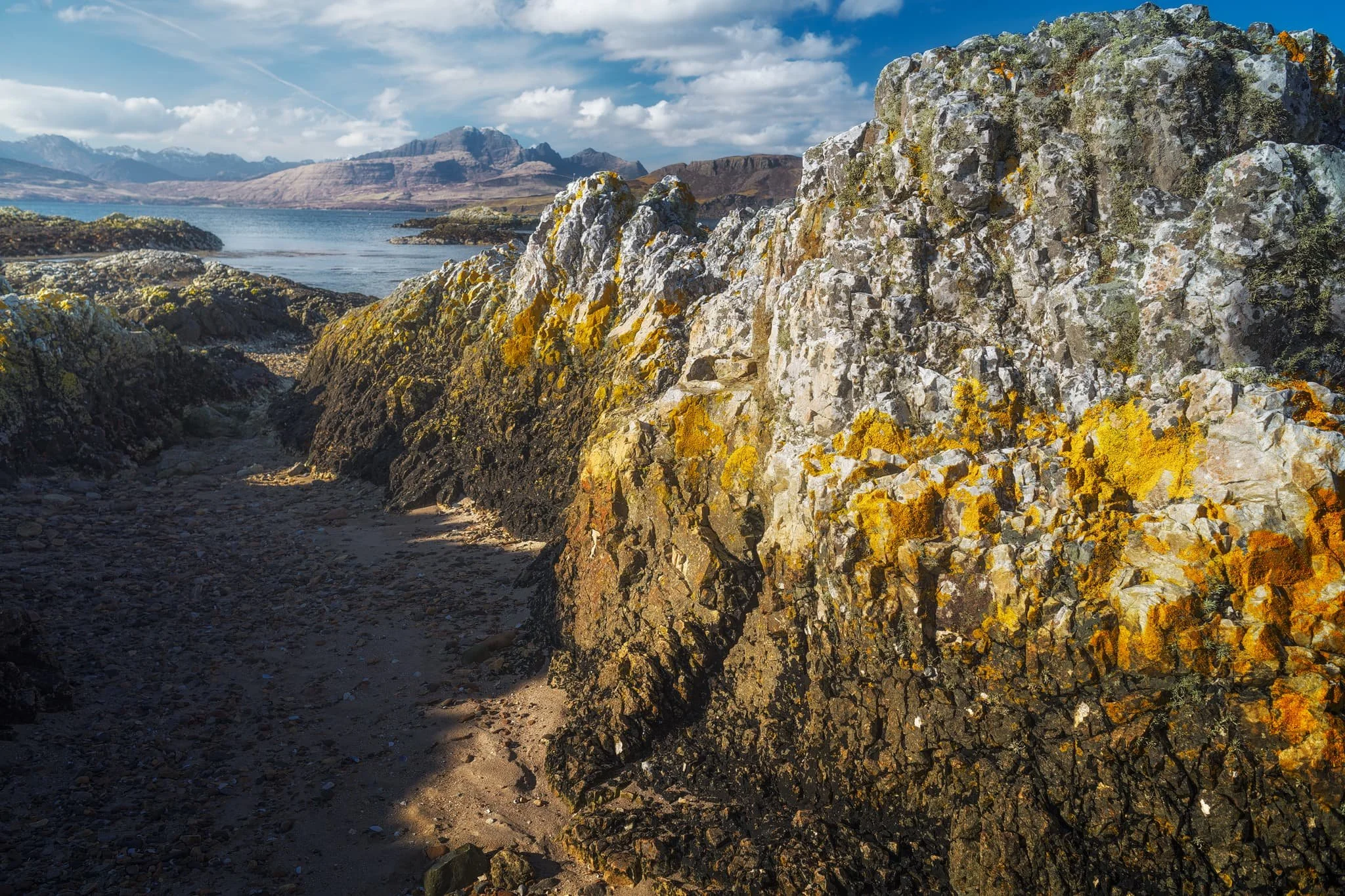 Further along the coastline we arrive at Ord, where one can take the minor road back over the Sleat peninsula to its southern shores. Before we did, we explored the bay here too. At Ord, you can find crags on the beach where old rocks meet some younger rocks called quartzites, and the younger rocks are found underneath the older ones, which is a bit unusual. The quartzites have some cool features, like cross-bedding (patterns in the rock) and folding (where the rock has been bent).