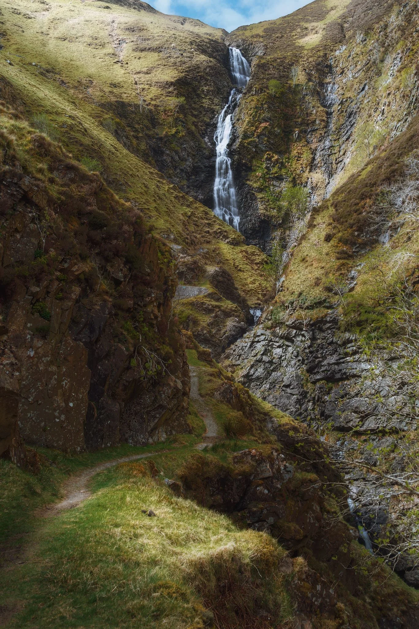 East from Moffat into Moffatdale the hills rise higher and higher as the valley closes in. Soon enough you’ll arrive at Grey Mare’s Tail Nature Reserve, which takes its name from the famous waterfall here, Grey Mare’s Tail. The last time we hiked up the trail towards this waterfall was November 2015, nearly a decade ago. The light conditions this time were favourable, sculpting the deep gorge created by the UK’s 5th highest waterfall, which drops 200 ft down.