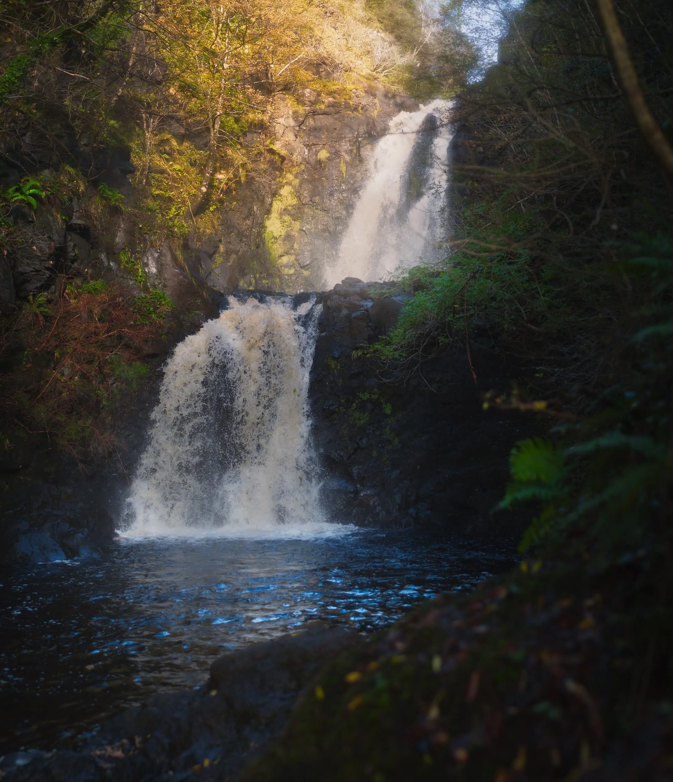 One of our “bookmarks” for October 2020’s Skye holiday was the Falls of Rha. These are a pair of powerful waterfalls located near Uig, north Skye. The falls are found in a wooded glen—relatively rare on Skye—and are almost disappointingly easy to get to. Nevertheless, they are an impressive site.