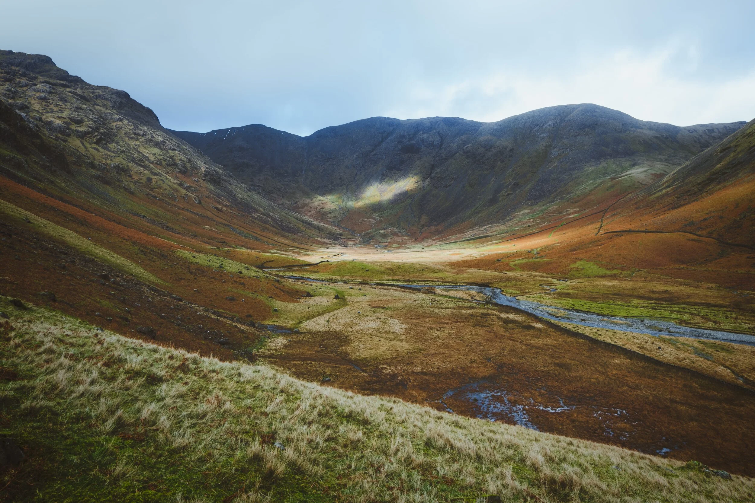 The full extent of the peaceful Mosedale valley, looking towards the crag wall of Pillar. Mosedale is a tributary valley that branches off the main Wasdale valley, and is a beautiful example of a smooth glaciated valley.
