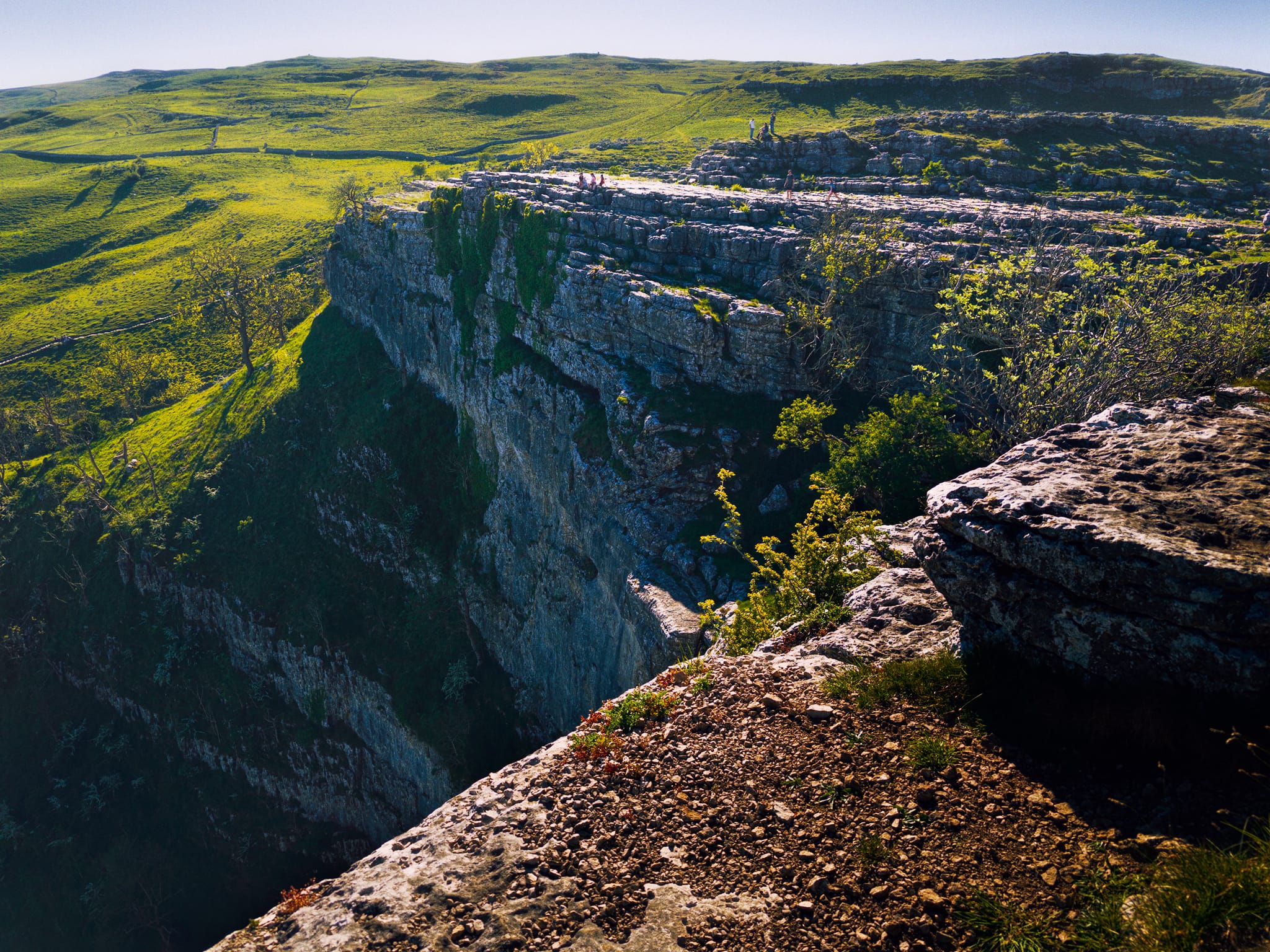 Looking across, and down, Malham Cove from its eastern edge. Imagine the sheer scale of the massive waterfall that would&rsquo;ve dropped from here.