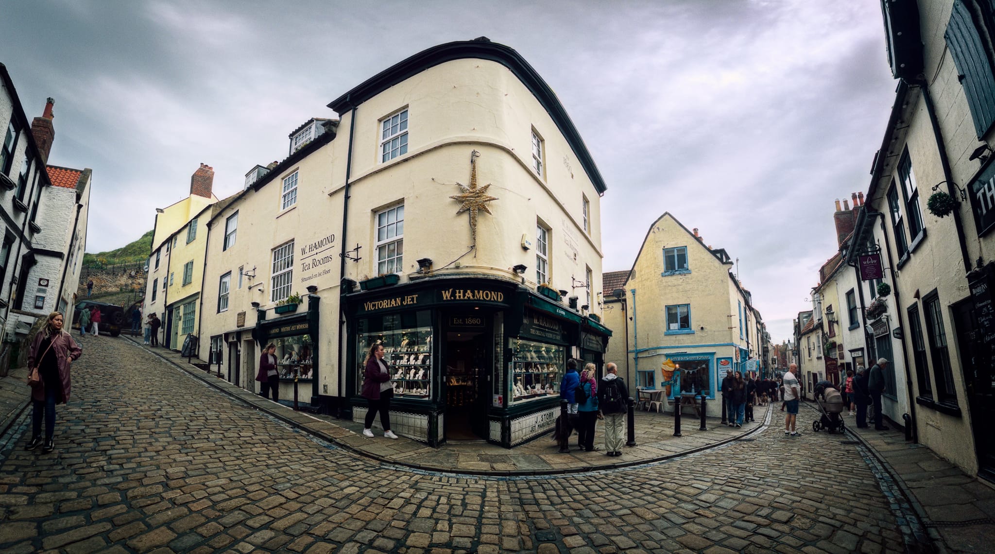 The iconic storefront of W Hamond - The Original Whitby Jet Shop, captured within a panorama. Established by James Storr in 1860, W Hamond is the town’s oldest surviving manufacturer and retailer of genuine Whitby Jet jewelry. Operated continuously from this exact same street corner for over 165 years. Crikey.